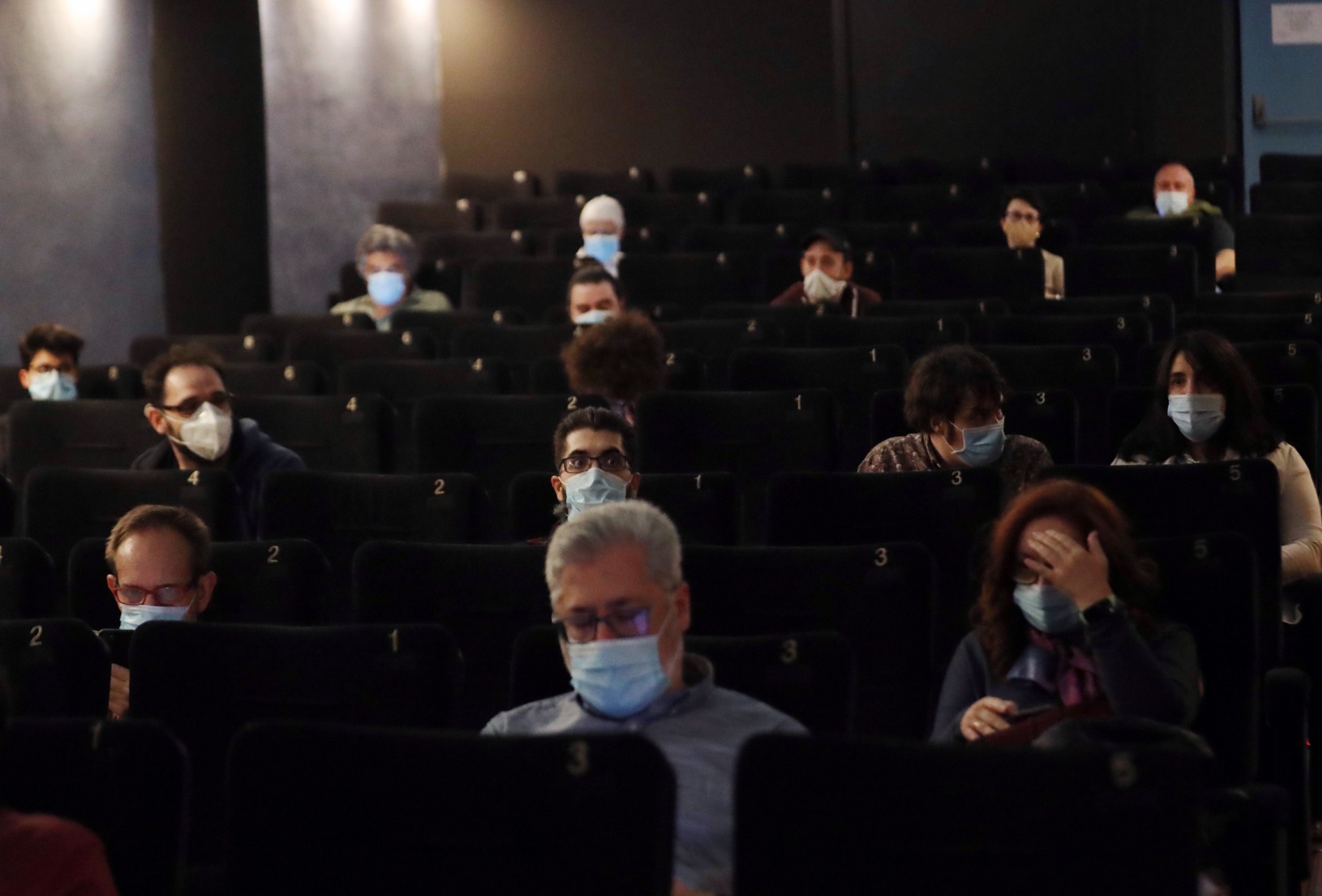 Espectadores ataviados con mascarillas asisten a la proyección de una película tras la reapertura del cine Renoir de Plaza de España, este viernes en Madrid.